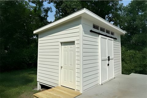 White finished backyard studio with sliding barn door and transom windows